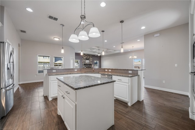 kitchen with stainless steel fridge, hanging light fixtures, and a large island