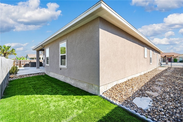 view of side of property with a yard and a patio