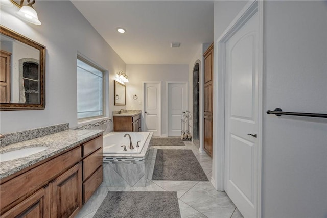 bathroom featuring vanity and tiled tub