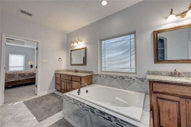 bathroom featuring vanity and tiled tub