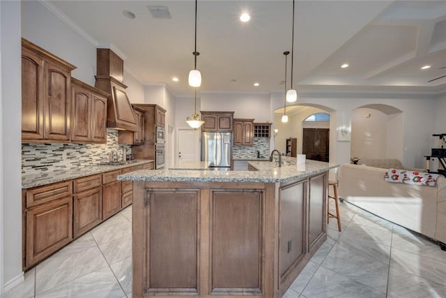 kitchen with decorative backsplash, a large island, pendant lighting, and appliances with stainless steel finishes