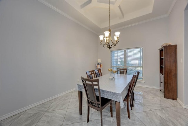 dining space featuring a raised ceiling, ornamental molding, and a notable chandelier