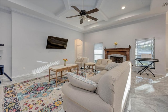 living room featuring a high ceiling, ceiling fan, coffered ceiling, and beam ceiling