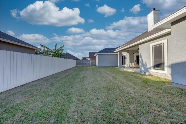 view of yard with ceiling fan and a patio area