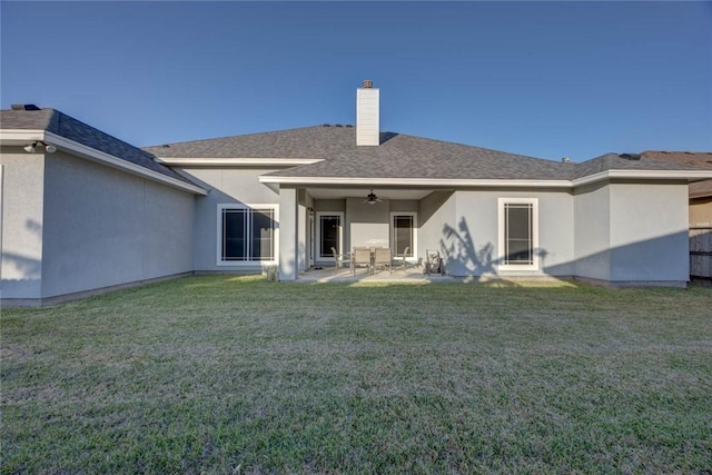 back of property with ceiling fan, a patio area, and a yard