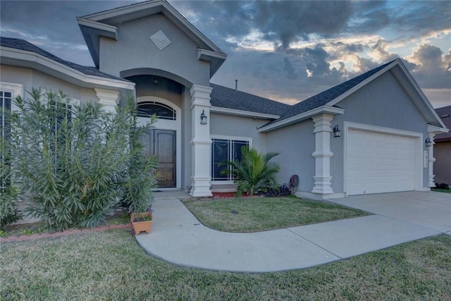 view of front of house featuring a garage and a lawn