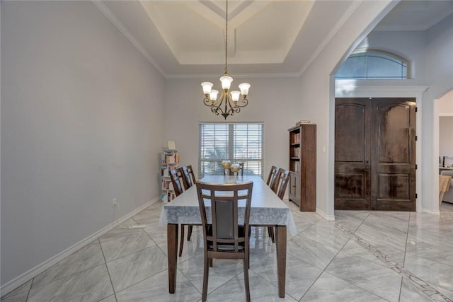 dining area with a tray ceiling and an inviting chandelier