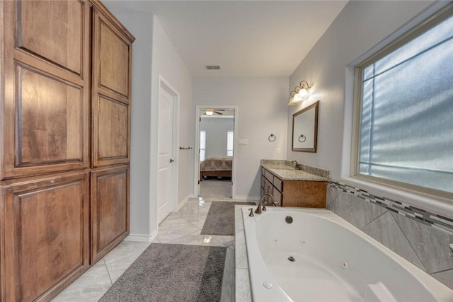 bathroom with tiled tub and vanity