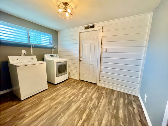 laundry area featuring washing machine and dryer and hardwood / wood-style flooring