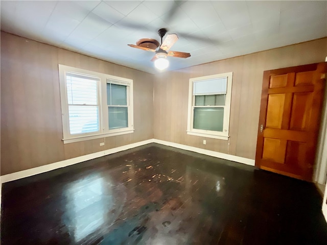 empty room with dark hardwood / wood-style flooring and ceiling fan