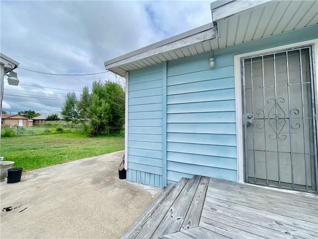 entrance to property with a lawn and a patio