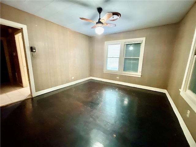 spare room featuring concrete floors and ceiling fan