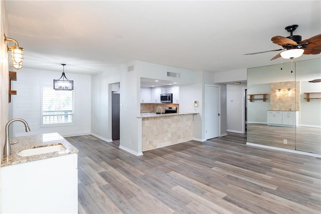 200 W Cotter Ave Unit B-3, Port Aransas, TX 78373 - kitchen featuring a sink, stainless steel appliances, white cabinets, and baseboards