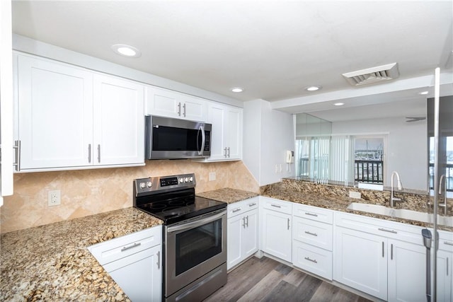 200 W Cotter Ave Unit B-3, Port Aransas, TX 78373 - kitchen with stainless steel appliances, a sink, white cabinets, light stone counters, and dark wood finished floors