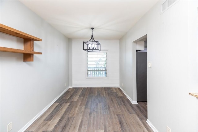 200 W Cotter Ave Unit B-3, Port Aransas, TX 78373 - unfurnished dining area with dark wood-style flooring, a chandelier, and baseboards