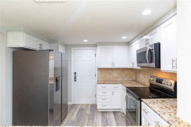 200 W Cotter Ave Unit B-3, Port Aransas, TX 78373 - kitchen with appliances with stainless steel finishes, white cabinetry, light wood-type flooring, light stone countertops, and recessed lighting