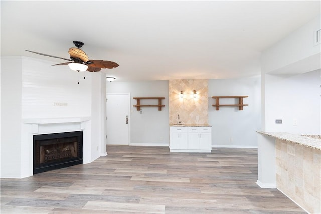 200 W Cotter Ave Unit B-3, Port Aransas, TX 78373 - unfurnished living room featuring a ceiling fan, light wood-type flooring, a fireplace, and baseboards