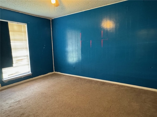 carpeted empty room featuring a textured ceiling