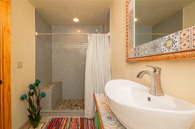 bathroom featuring walk in shower, sink, and tile patterned flooring