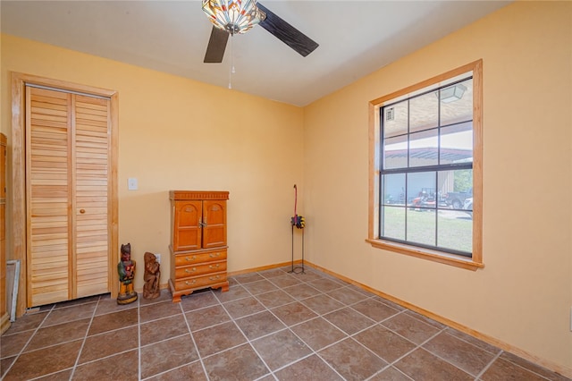 interior space featuring dark tile patterned flooring and ceiling fan