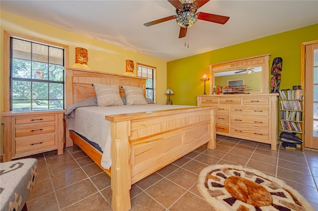 tiled bedroom featuring ceiling fan and multiple windows