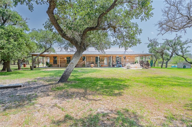 rear view of house featuring a yard