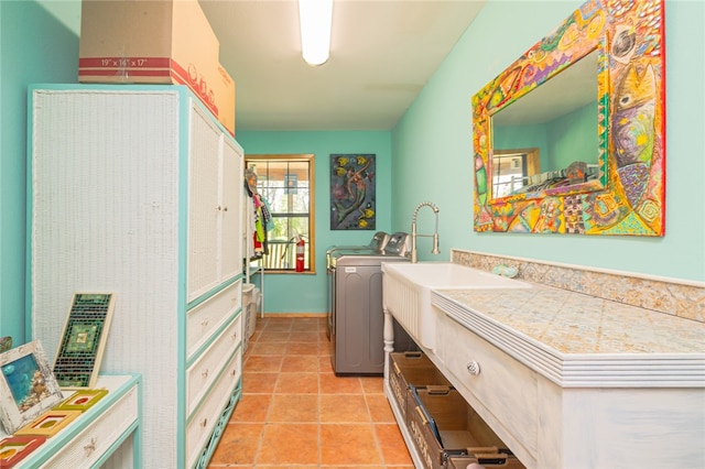 washroom featuring washer / clothes dryer, sink, and light tile patterned floors