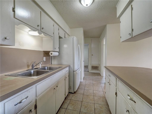 1638 Spicewood Dr, Corpus Christi, TX 78412 - kitchen featuring a textured ceiling, light tile patterned floors, white cabinets, and light countertops