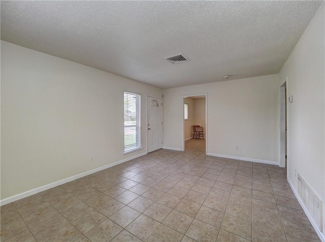 1638 Spicewood Dr, Corpus Christi, TX 78412 - empty room featuring a textured ceiling and light tile patterned flooring