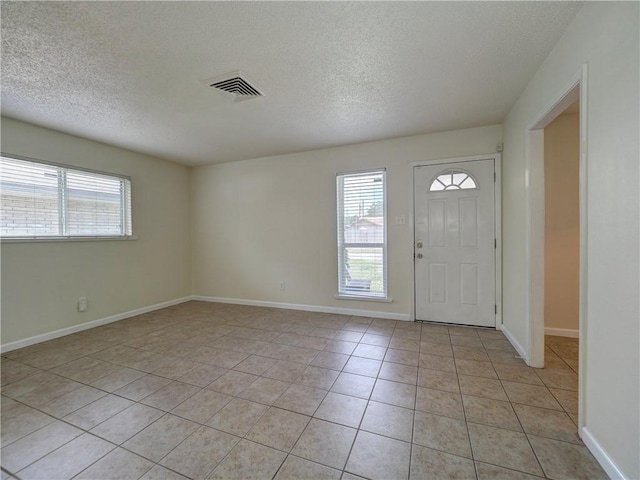 1638 Spicewood Dr, Corpus Christi, TX 78412 - entryway featuring a textured ceiling, plenty of natural light, and light tile patterned flooring