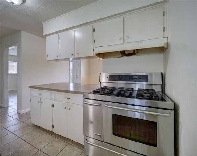 1638 Spicewood Dr, Corpus Christi, TX 78412 - kitchen featuring double oven range, under cabinet range hood, white cabinetry, light tile patterned floors, and a textured ceiling
