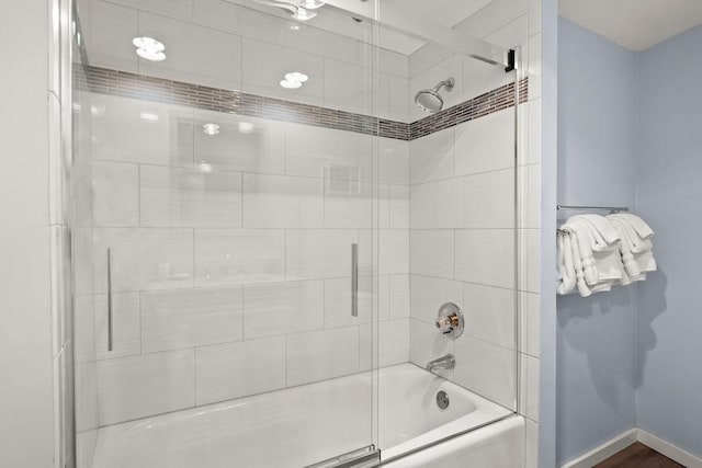 bathroom featuring combined bath / shower with glass door