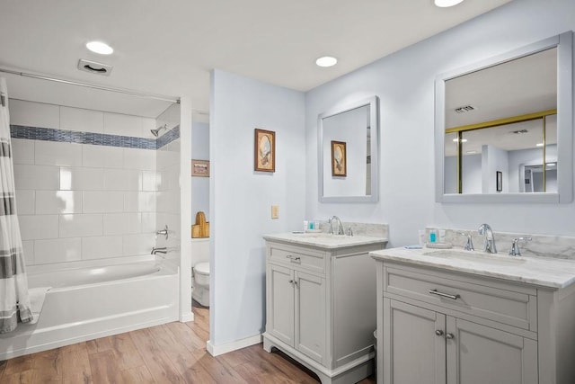 full bathroom featuring hardwood / wood-style flooring, shower / tub combo with curtain, vanity, and toilet