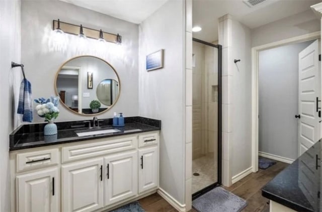 bathroom with baseboards, a stall shower, and vanity