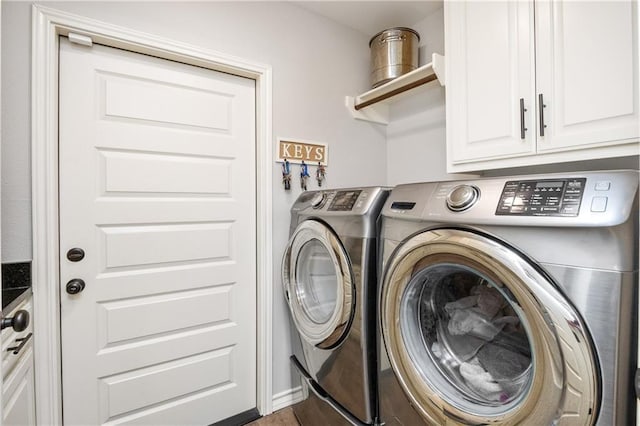 washroom featuring cabinet space and washer and clothes dryer