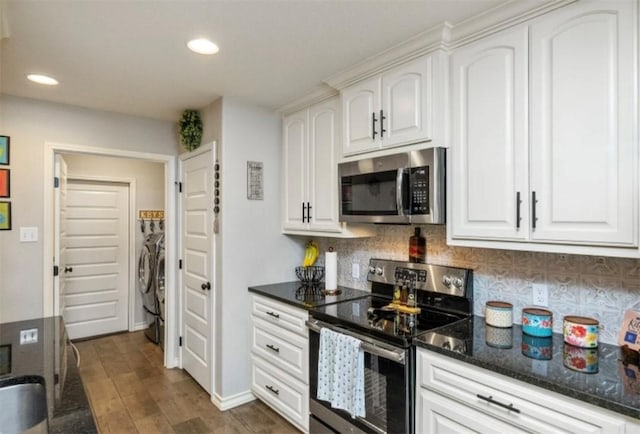 kitchen featuring white cabinets, appliances with stainless steel finishes, decorative backsplash, and washer and clothes dryer