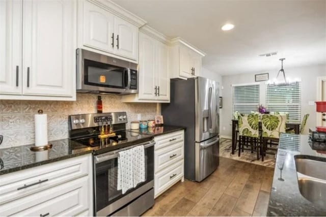 kitchen featuring white cabinets, stainless steel appliances, and tasteful backsplash