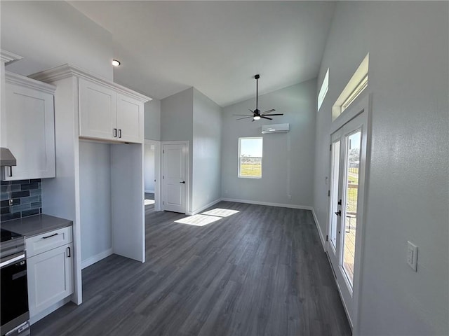 kitchen with dark wood-type flooring, white cabinetry, backsplash, vaulted ceiling, and a wall mounted air conditioner