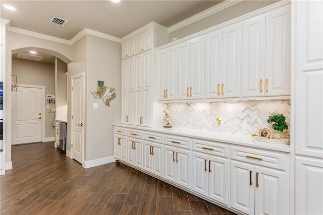 8102 Nazareth Dr, Corpus Christi, TX 78413 - kitchen with arched walkways, white cabinetry, baseboards, dark wood-style floors, and ornamental molding