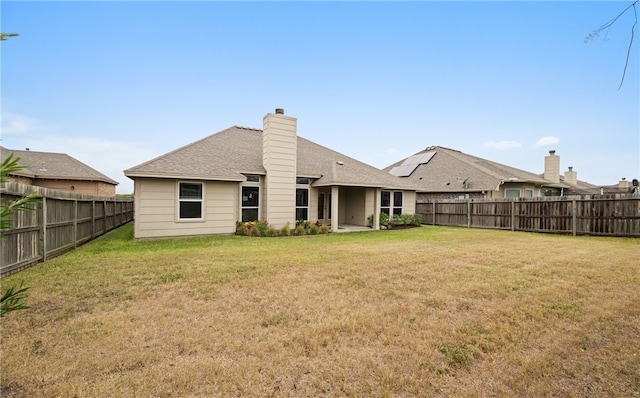 rear view of house featuring a yard