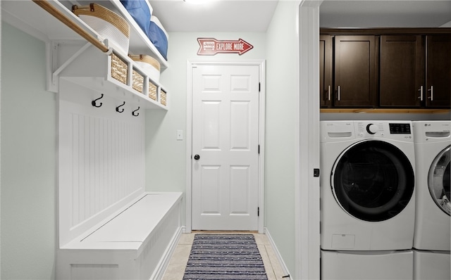 clothes washing area featuring separate washer and dryer and cabinets