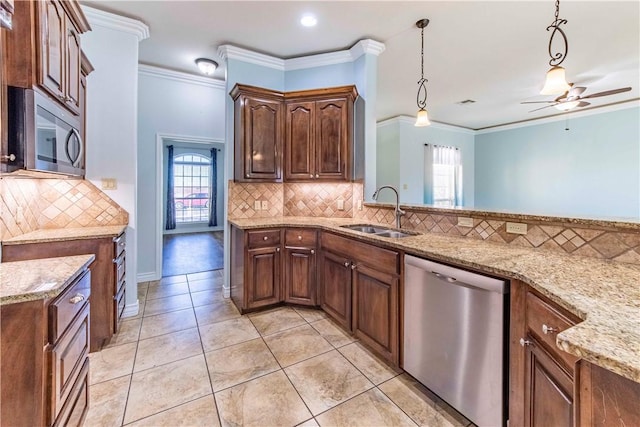 kitchen featuring appliances with stainless steel finishes, pendant lighting, a sink, and ornamental molding