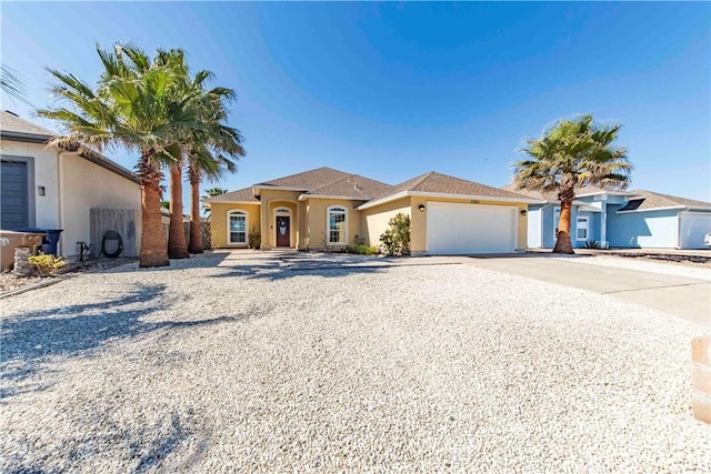 view of front of house featuring a garage, concrete driveway, and stucco siding