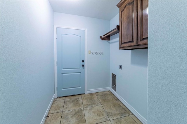 washroom featuring light tile patterned floors, cabinet space, electric dryer hookup, and baseboards