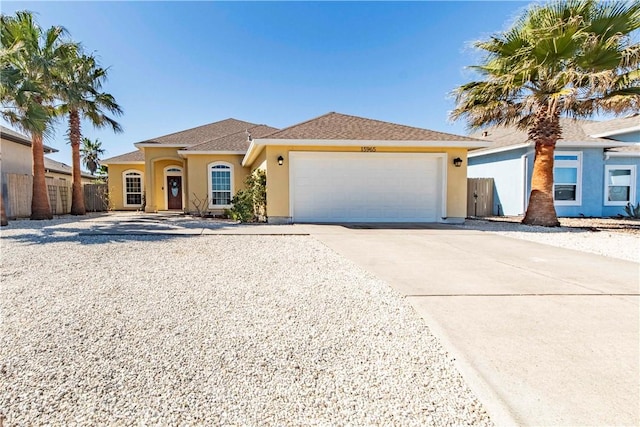 view of front facade featuring an attached garage, driveway, a shingled roof, and stucco siding