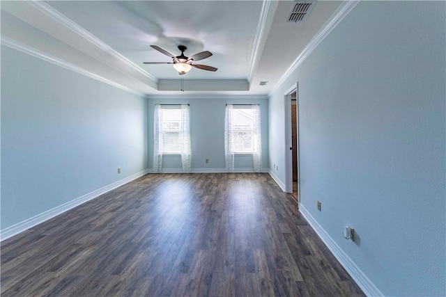 spare room featuring baseboards, visible vents, a raised ceiling, and dark wood finished floors