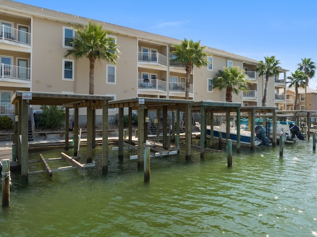 view of dock with a balcony and a water view