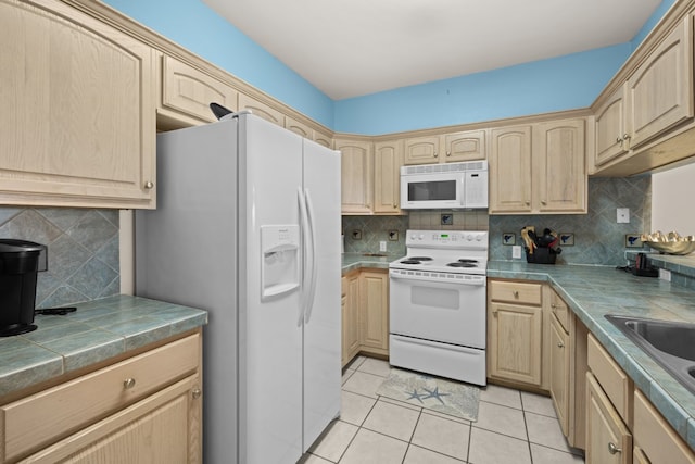 kitchen featuring white appliances, tile countertops, light brown cabinetry, and light tile patterned flooring