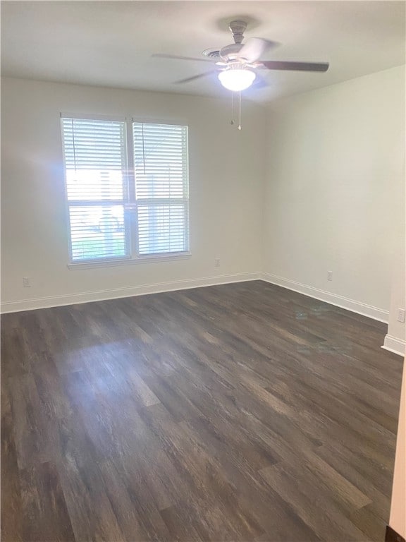 unfurnished room with dark wood-type flooring and ceiling fan