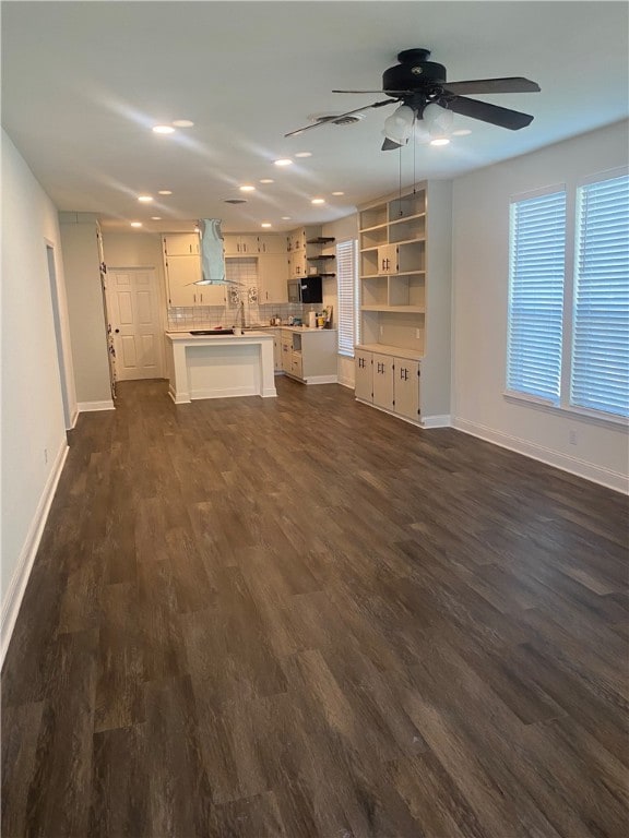 unfurnished living room with ceiling fan and dark hardwood / wood-style floors